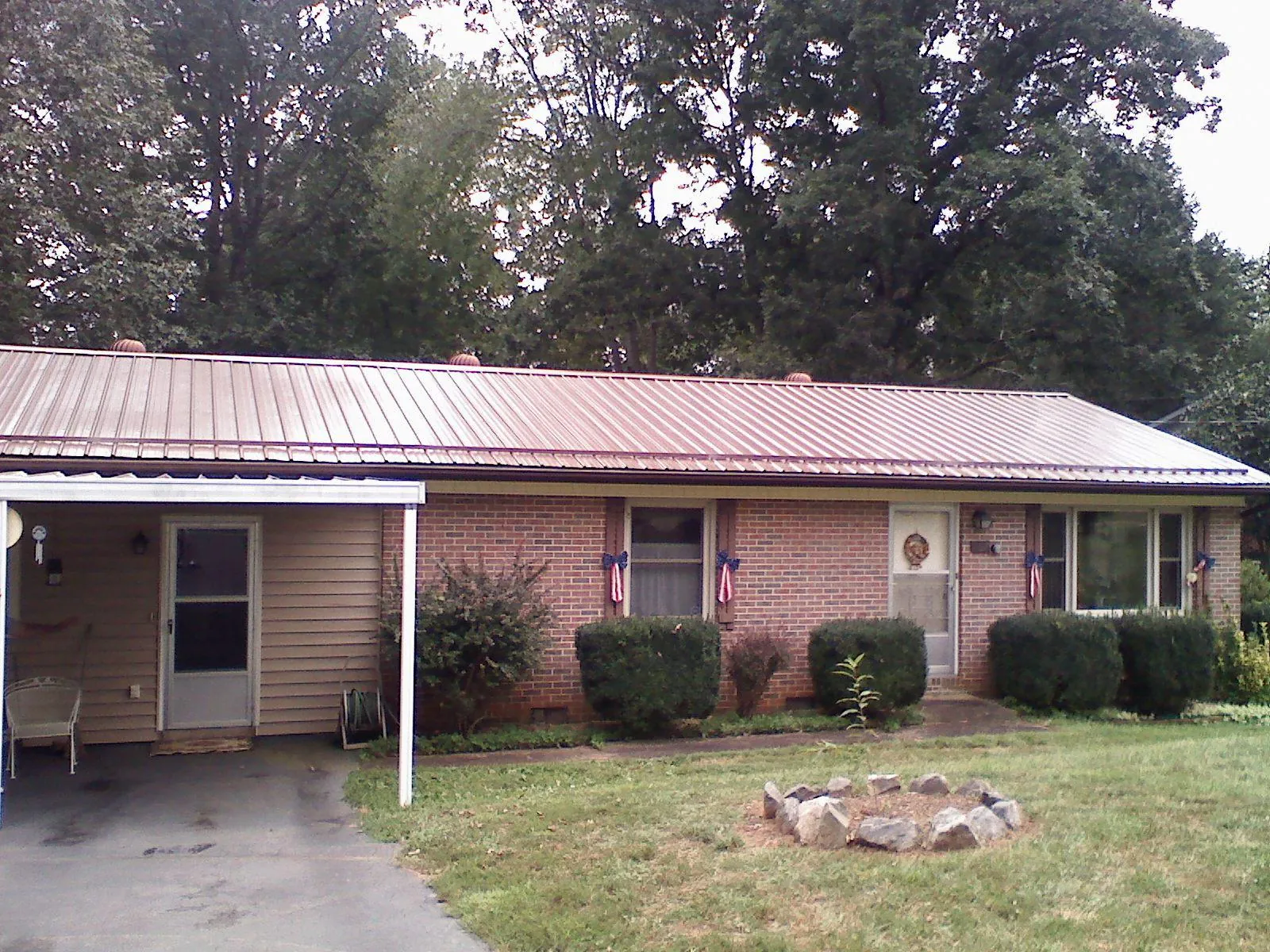 Bronze metal roof and carport on a brick ranch home — Roof Repair work by our crew in Stonyford